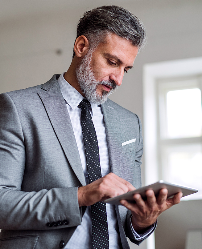 a man in a suit and tie using a tablet