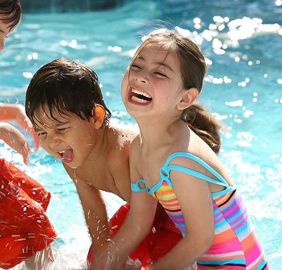 a group of children playing in a pool