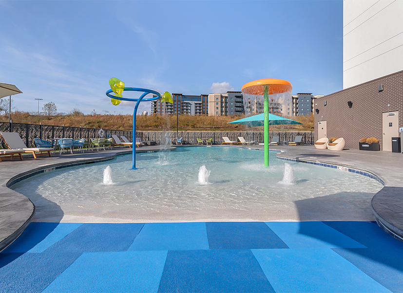 a pool with water fountains and umbrellas