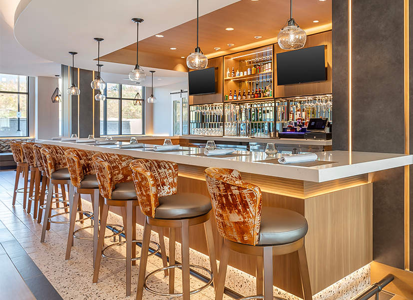 a bar with a row of chairs and a television on the wall
