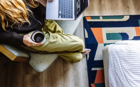 a woman sitting on a couch using a laptop