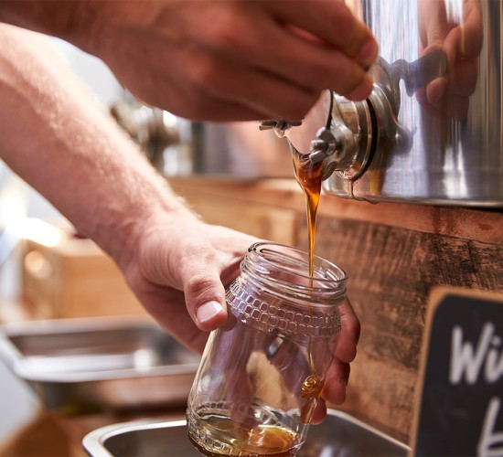 a person pouring a drink into a glass