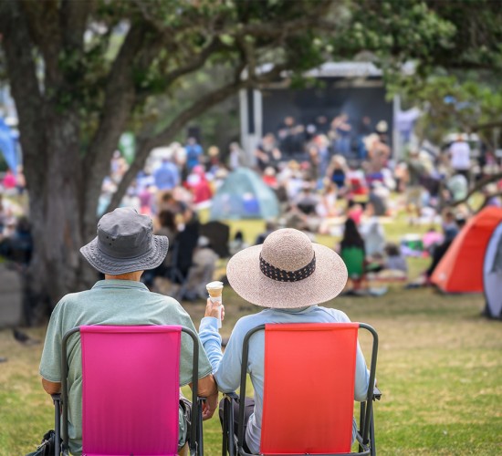 a man and woman sitting in chairs at a picnic