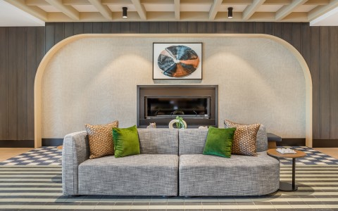 a couch with pillows in a room with a fireplace