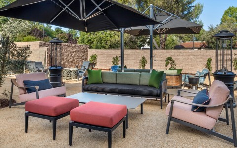 a patio with a couch and umbrella