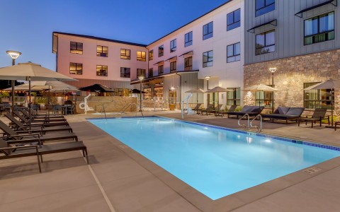 a pool and umbrellas in front of a building