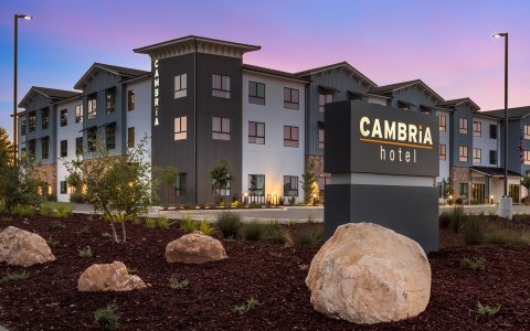 a hotel with a sign and rocks in front of it