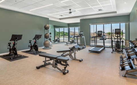 a room with exercise equipment and a large window