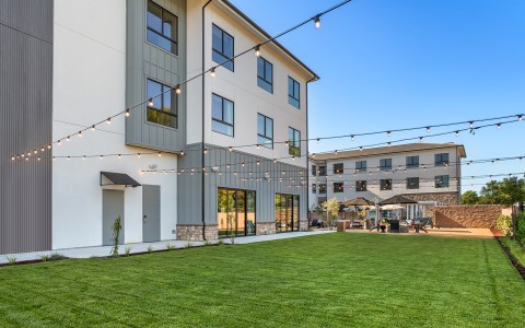 a building with a lawn and string lights