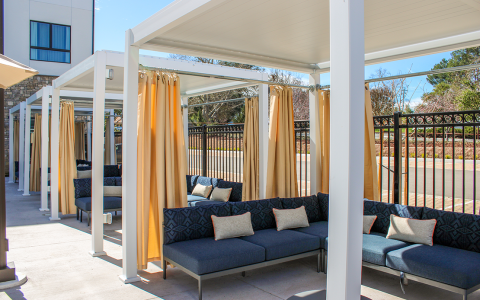 a patio with couches and curtains
