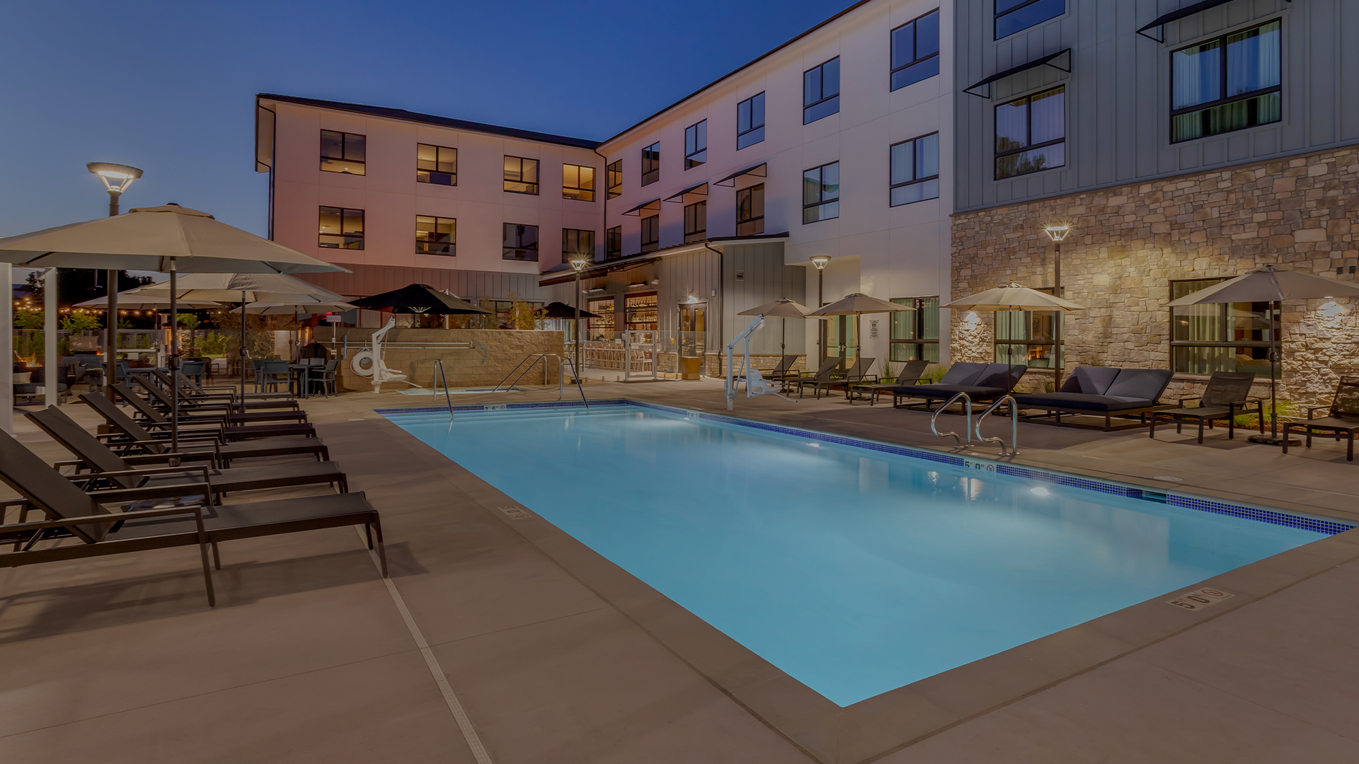 a pool and umbrellas in front of a building