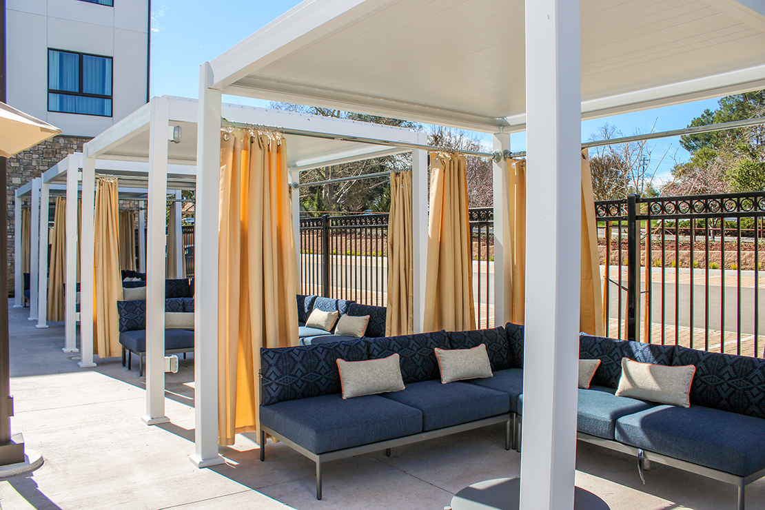 a patio with couches and curtains
