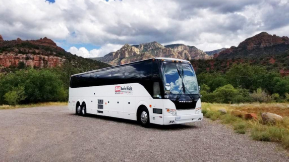 a white bus parked on a gravel road