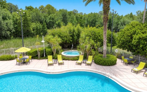 a pool with lounge chairs and a hot tub