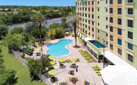 a pool and chairs by a building