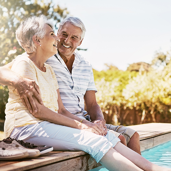 older couple smiling by the pool