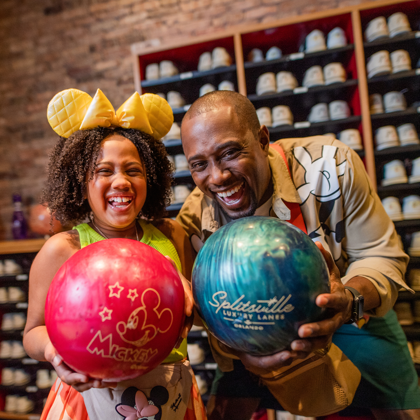 a man and a girl holding bowling balls