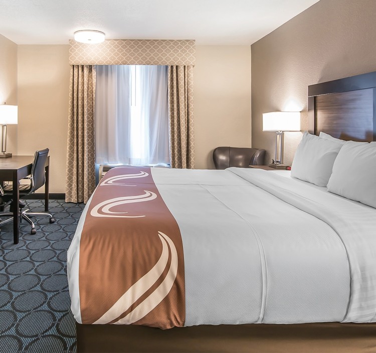 a hotel room with a bed and desk