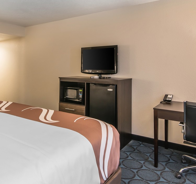 a room with a bed and a small refrigerator