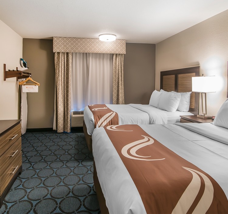 a room with two beds and a dresser