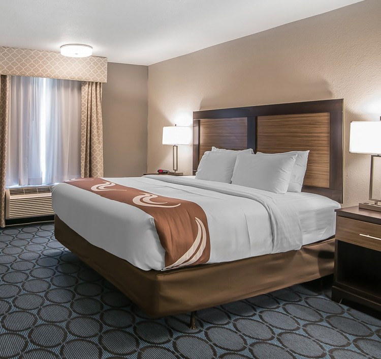 a hotel room with a bed and a lamp