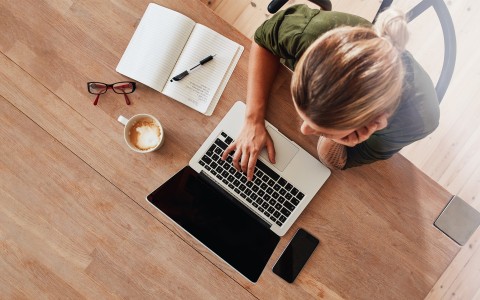 a woman sitting at a desk using a laptop