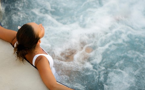 a woman in a white tank top standing in a pool