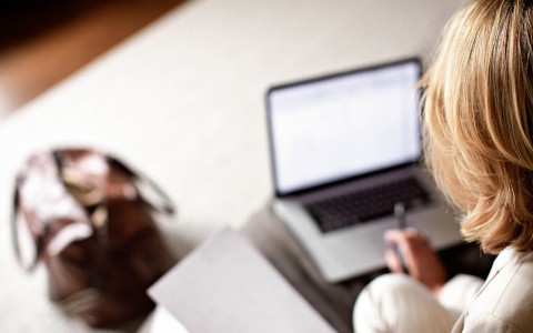 a woman sitting on a couch using a laptop