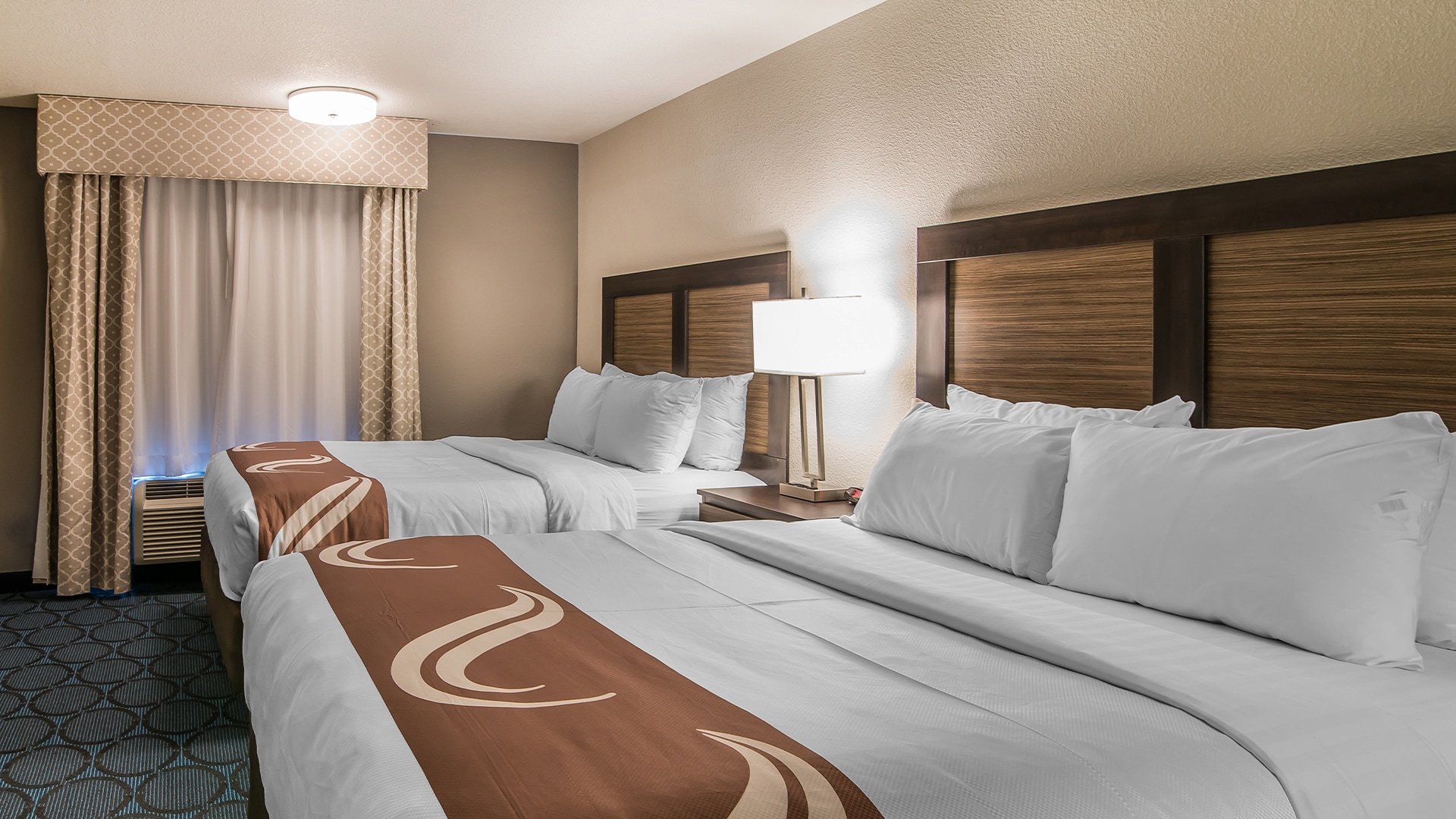 a room with two beds and a lamp