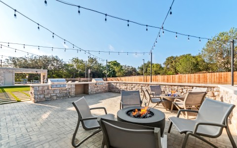 a patio with chairs and a fire pit