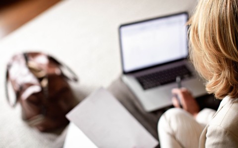 a blurry image of a woman using a laptop