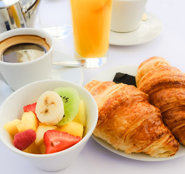 a plate of croissants and fruit on a white plate
