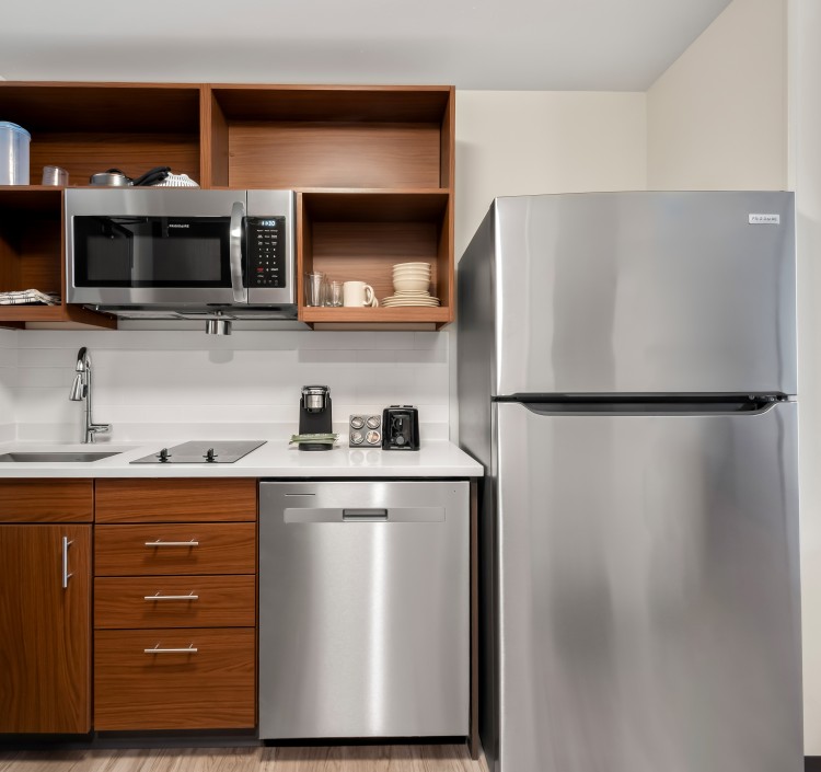 a kitchen with a stainless steel refrigerator and a wood cabinet