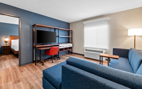 a room with blue couches and a tv